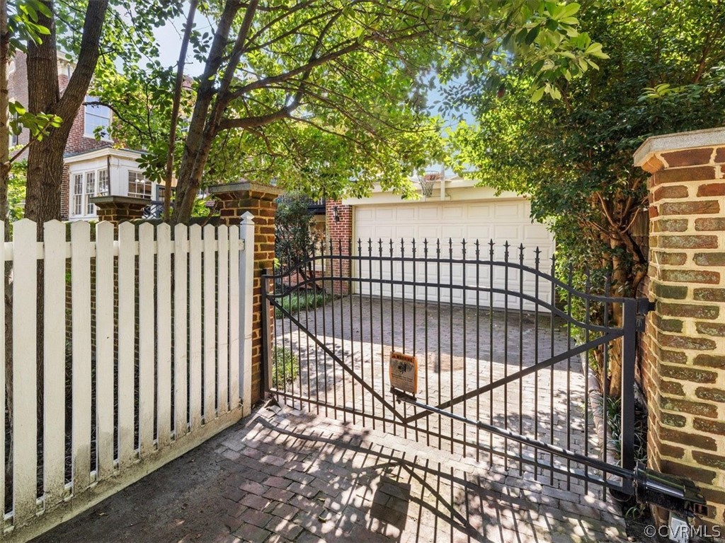 An electric gate opens into the garden from a rear alley