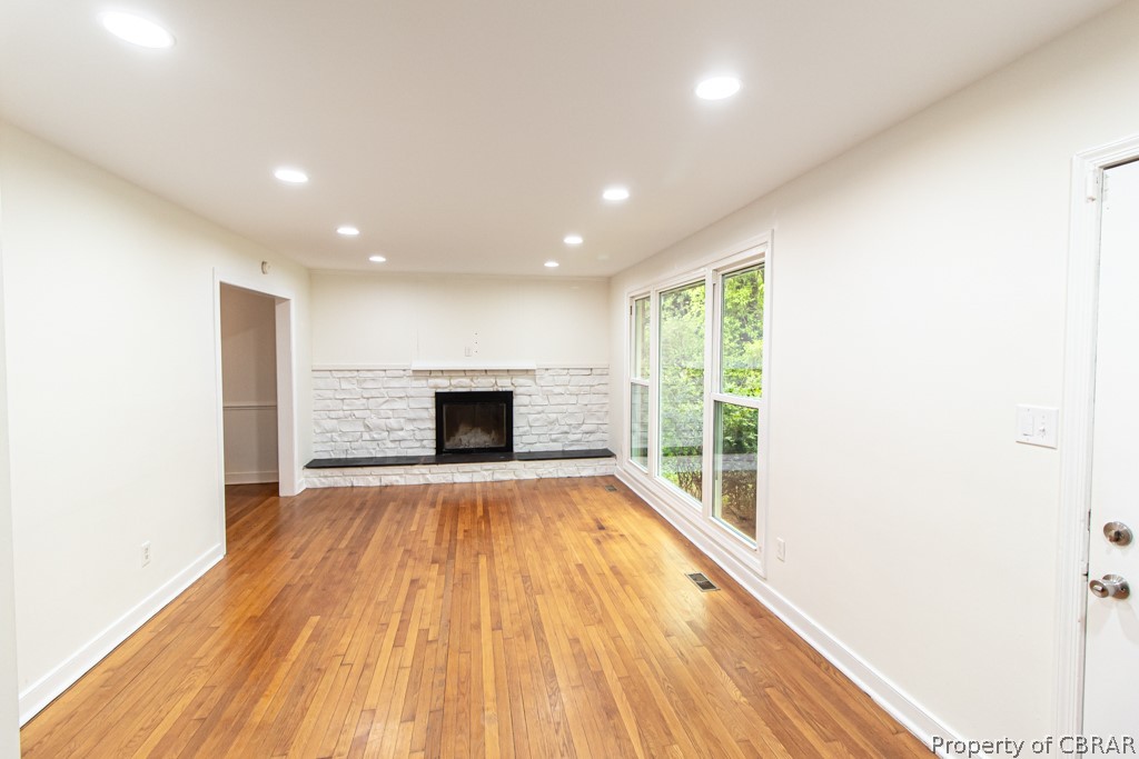 Unfurnished living room featuring light hardwood / wood-style flooring and a fireplace