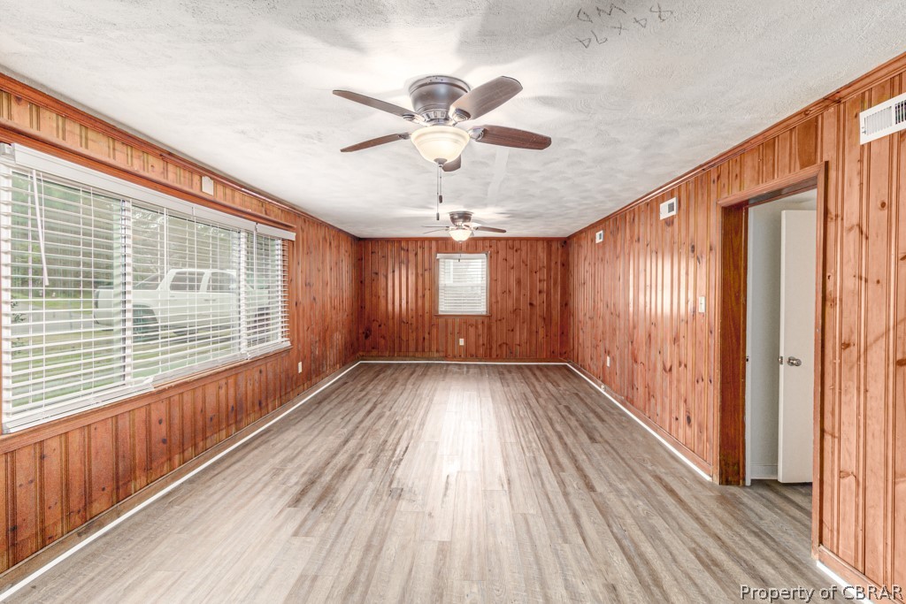 Unfurnished room with plenty of natural light, ceiling fan, and light wood-type flooring