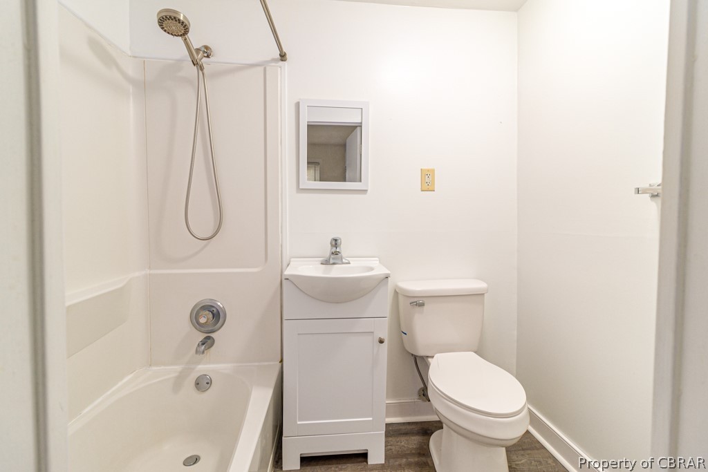 Full bathroom with washtub / shower combination, vanity, and toilet