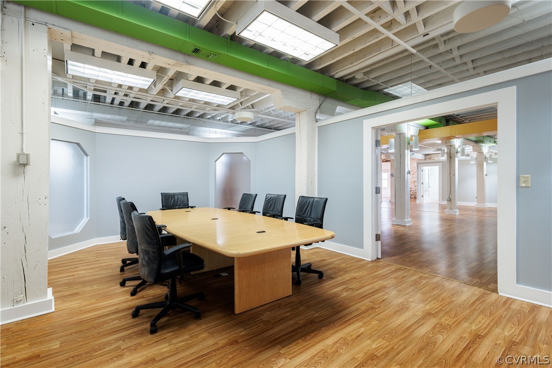 Office space with decorative columns and light hardwood / wood-style floors