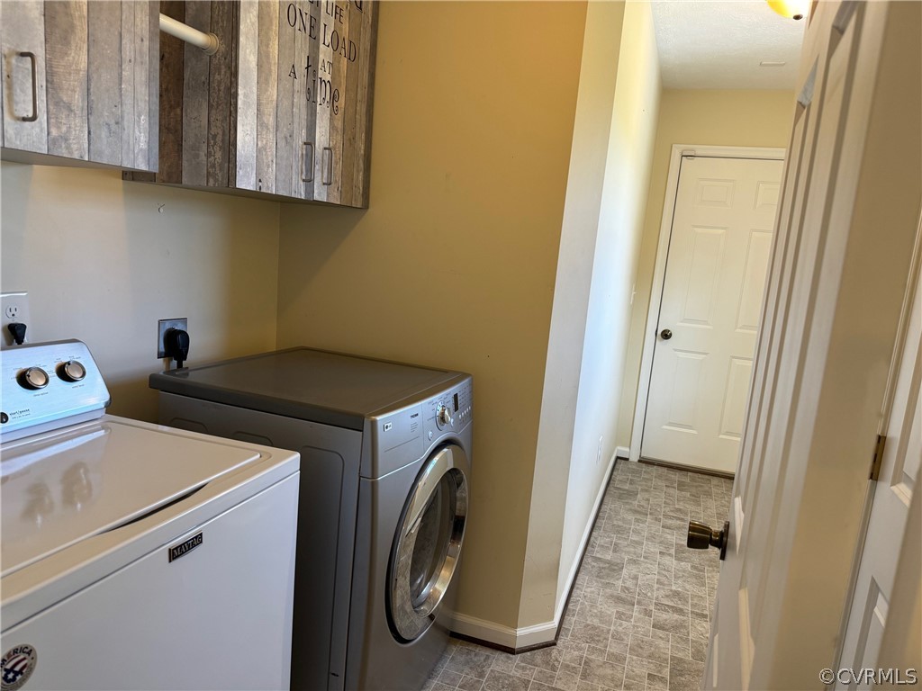 Laundry room with independent washer and dryer, cabinets, electric dryer hookup, and light floors