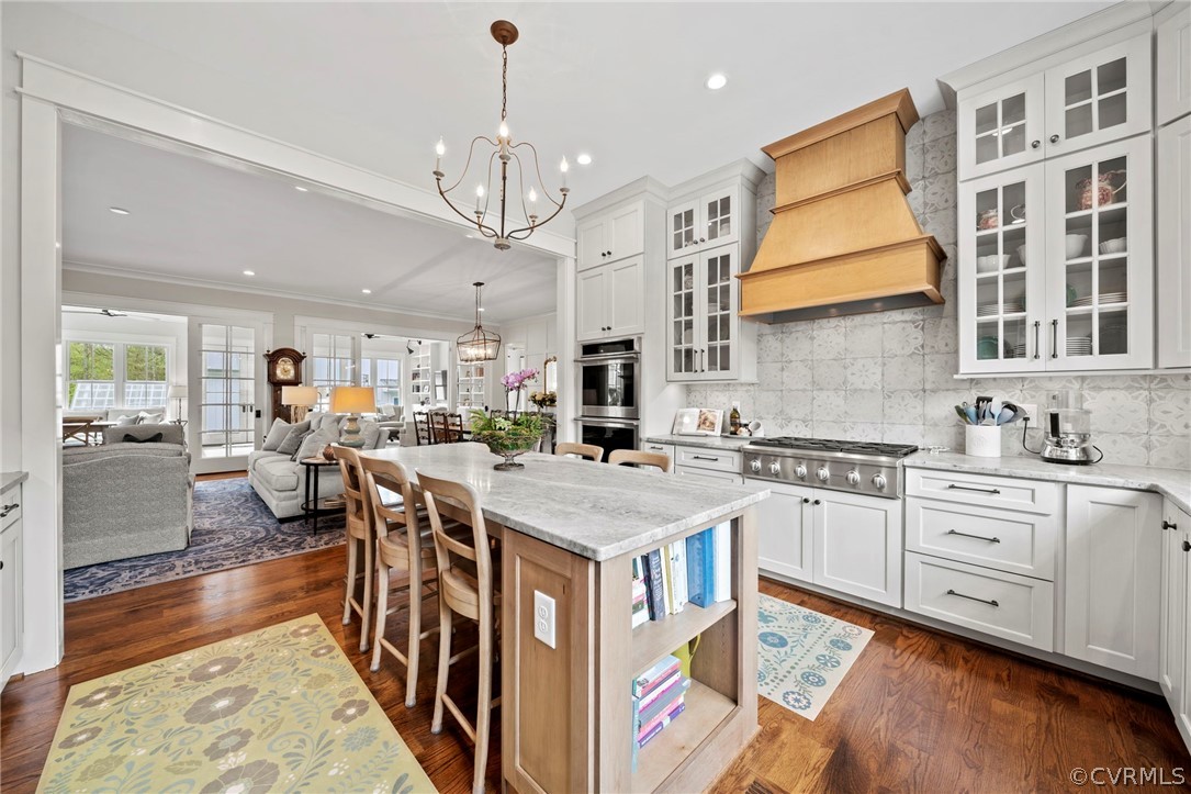 Kitchen with dark hardwood / wood-style floors, a kitchen island, white cabinets, and premium range hood