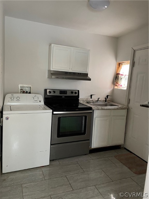 Clothes washing area featuring washer / clothes dryer, tile flooring, and sink