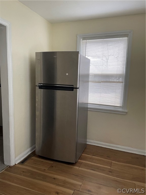 Kitchen with stainless steel fridge and dark wood-type flooring