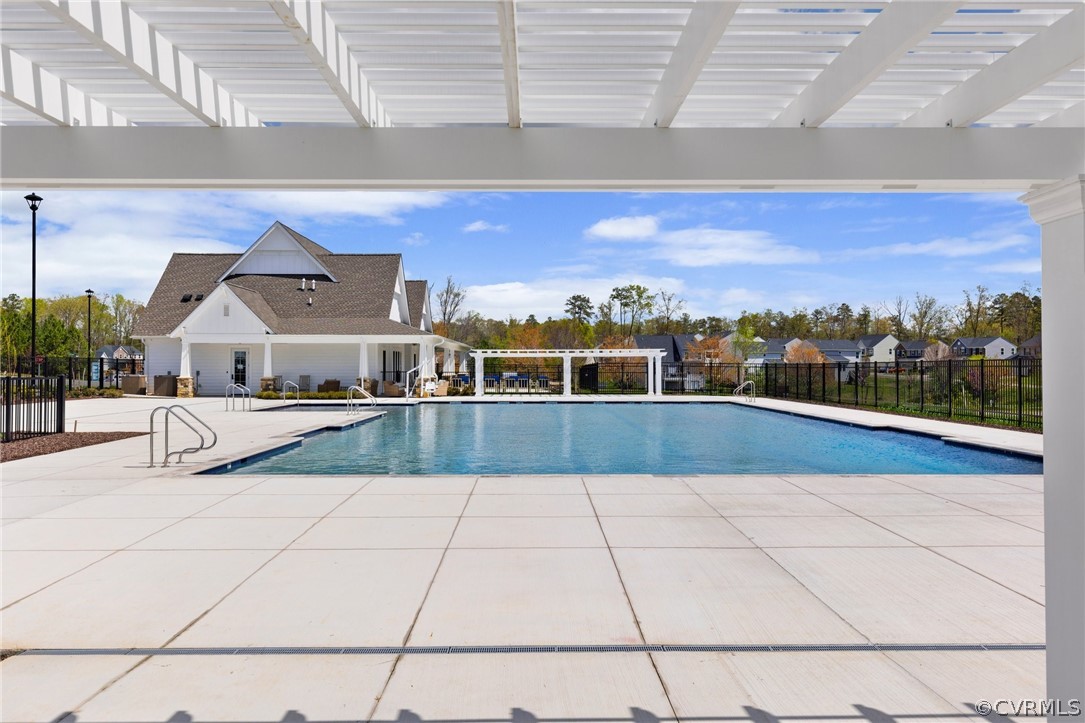 View of pool with a pergola and a patio area