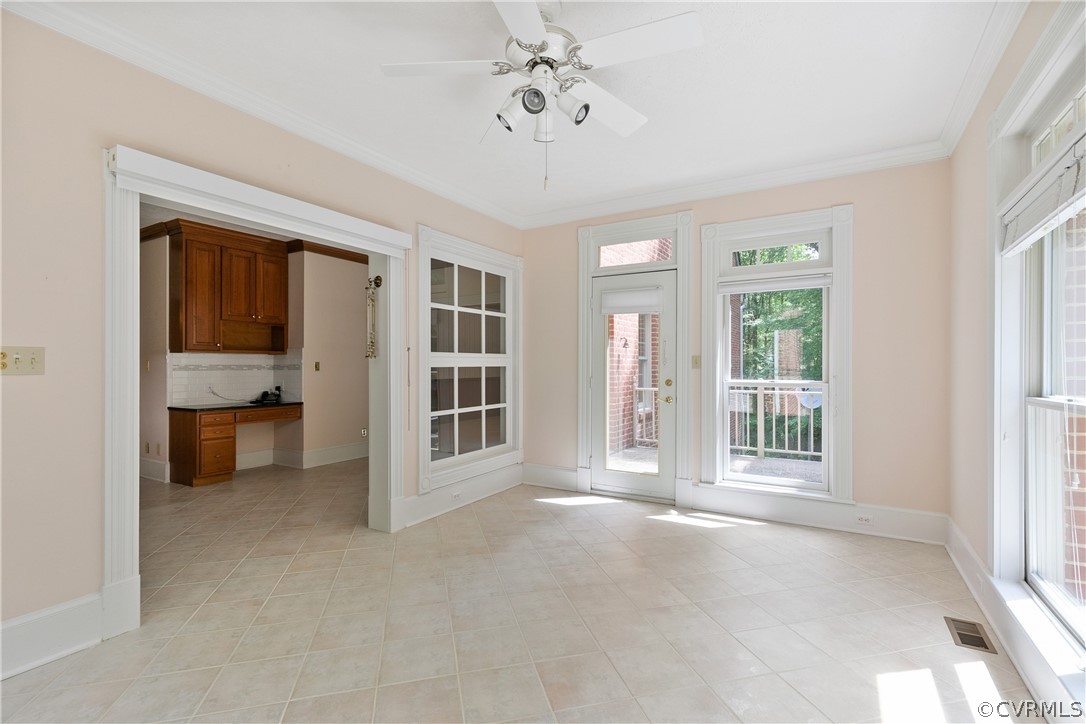 Tiled dining room featuring crown molding, a wealth of natural light, and ceiling fan