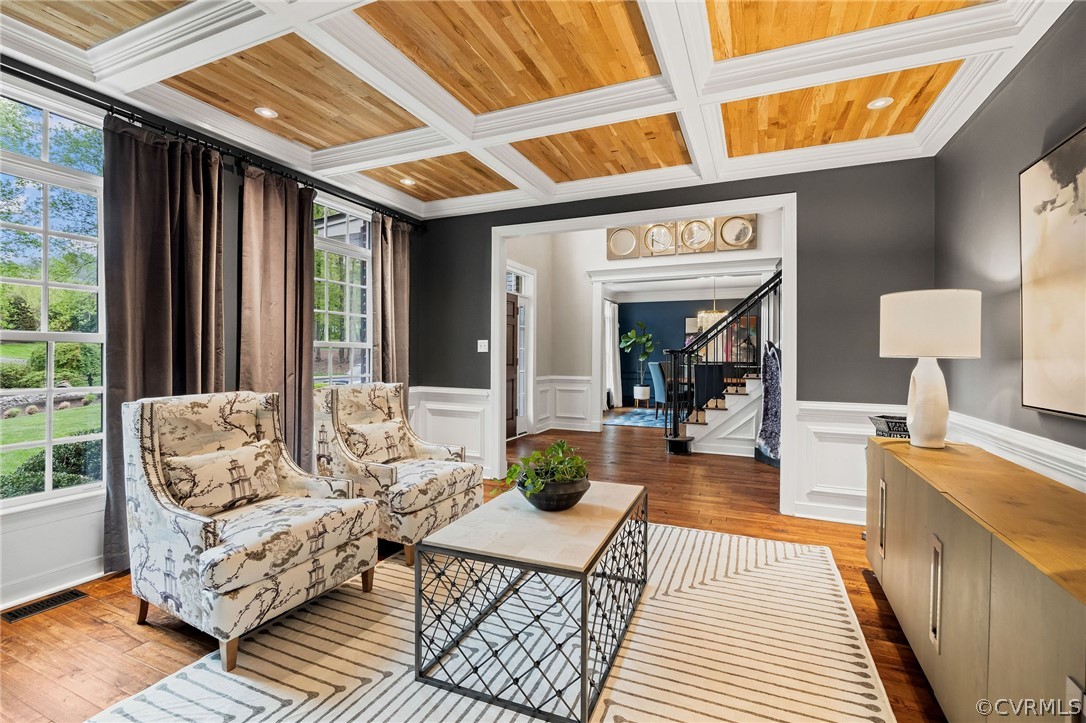 Living area with wooden ceiling, plenty of natural light, crown molding, and coffered ceiling