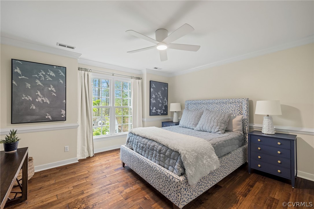 Bedroom with ornamental molding, ceiling fan, and dark wood-type flooring
