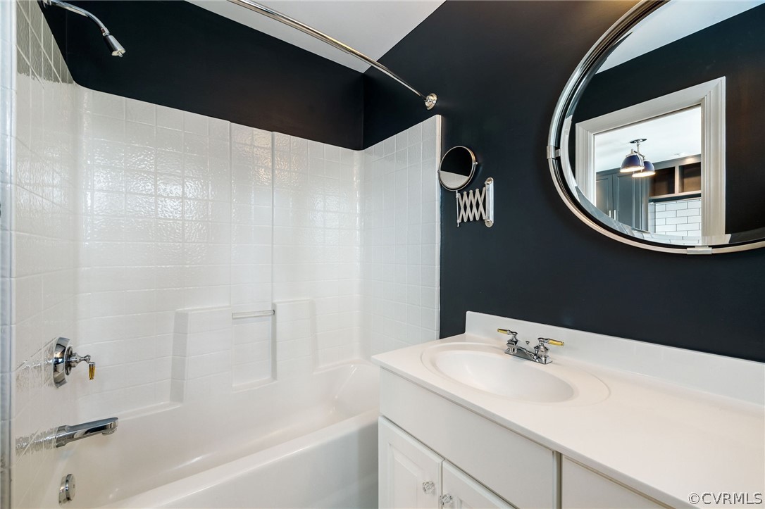 Bathroom featuring large vanity and bathing tub / shower combination