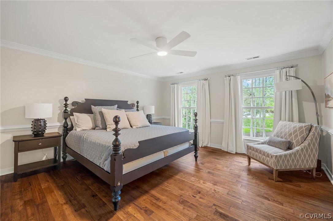 Bedroom with ceiling fan, dark hardwood / wood-style flooring, and ornamental molding