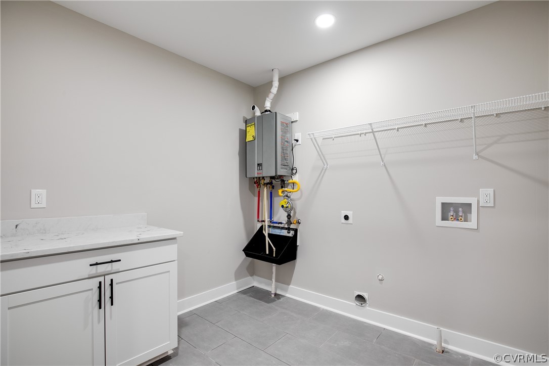 Laundry room featuring hookup for an electric dryer, hookup for a washing machine, cabinets, water heater, and light tile floors