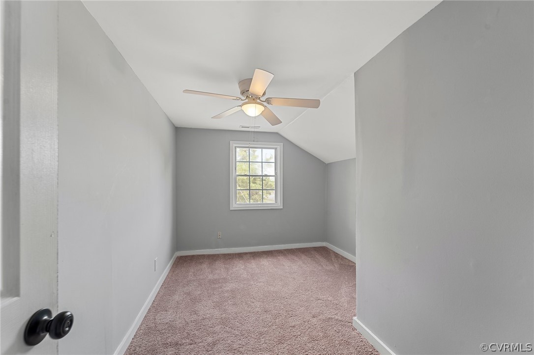 Additional living space with light carpet, lofted ceiling, and ceiling fan