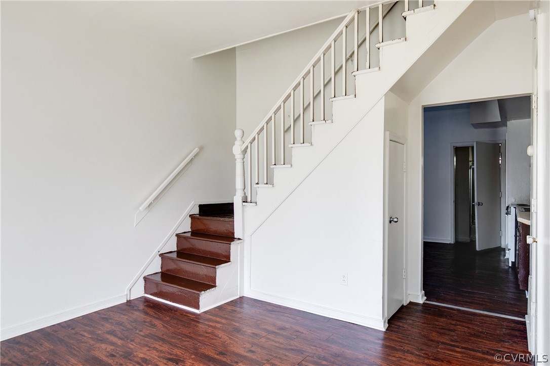 Staircase featuring dark wood-type flooring