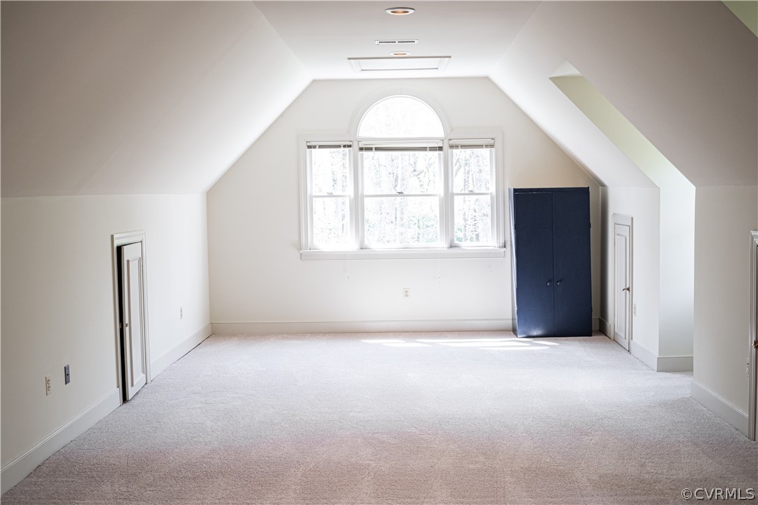 Large upstairs bedroom with storage and dormer windows.