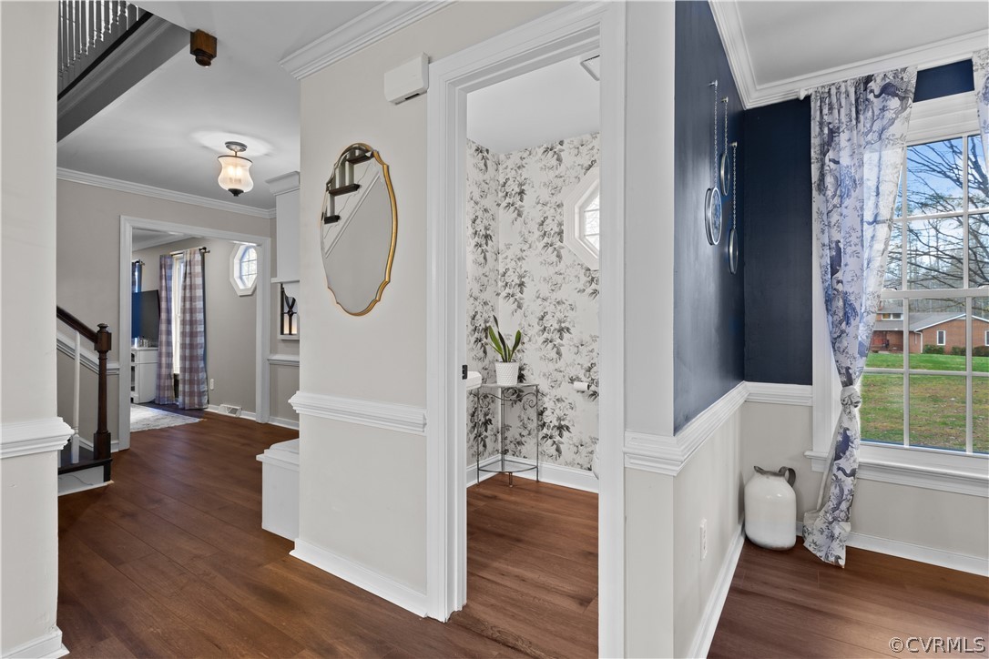 Entryway with ornamental molding and dark hardwood / wood-style floors
