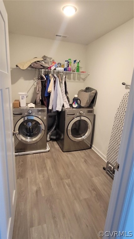 Laundry room featuring hardwood / wood-style flooring and washing machine and clothes dryer