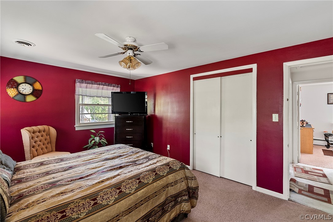 Bedroom featuring ceiling fan, carpet flooring, and baseboard heating