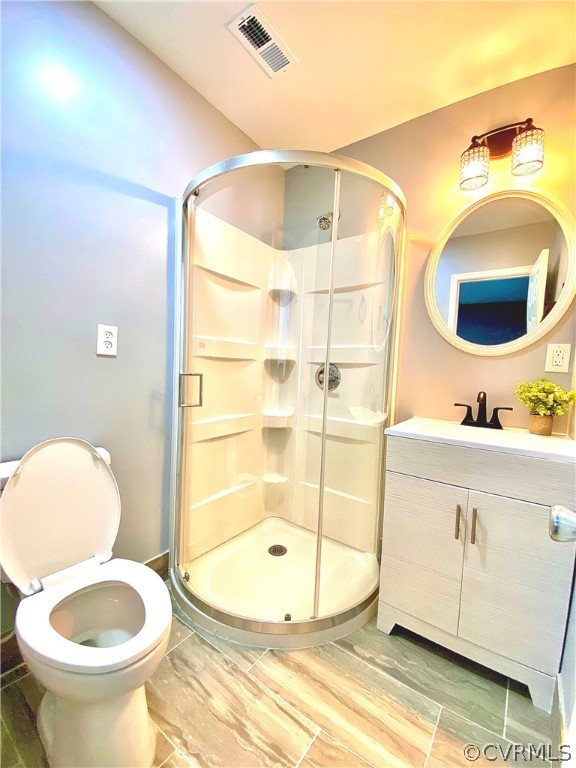 Bathroom with an enclosed shower, toilet, and vanity with extensive cabinet space