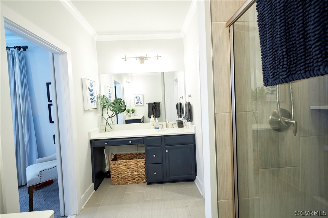 Bathroom featuring ornamental molding, an enclosed shower, oversized vanity, and tile flooring