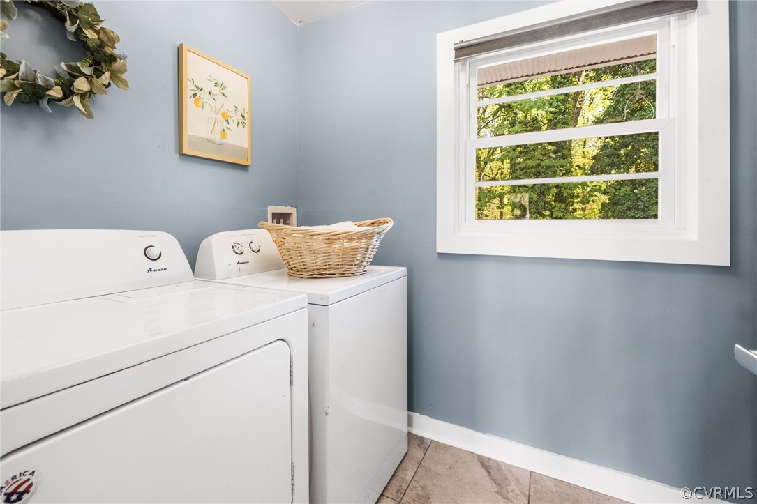Laundry room with light tile floors and washer and dryer