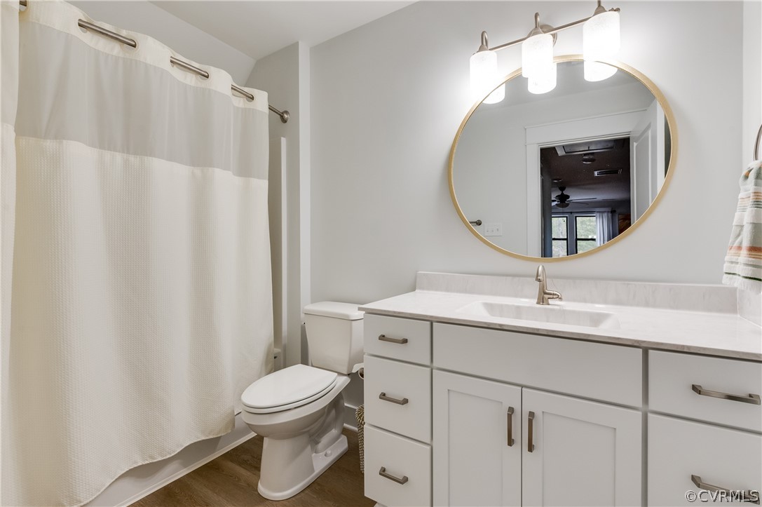 Bathroom with vanity, hardwood / wood-style flooring, and​​‌​​​​‌​​‌‌​‌‌​​​‌‌​‌​‌​‌​​​‌​​ toilet