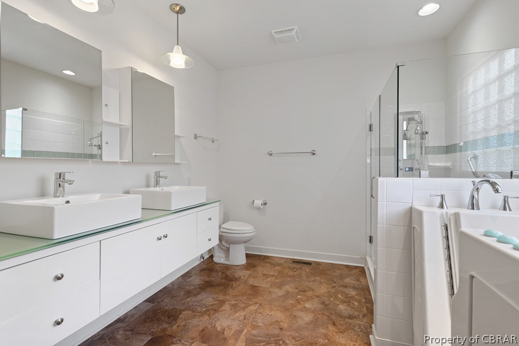Full bathroom with independent shower and bath, tile floors, toilet, and double sink vanity