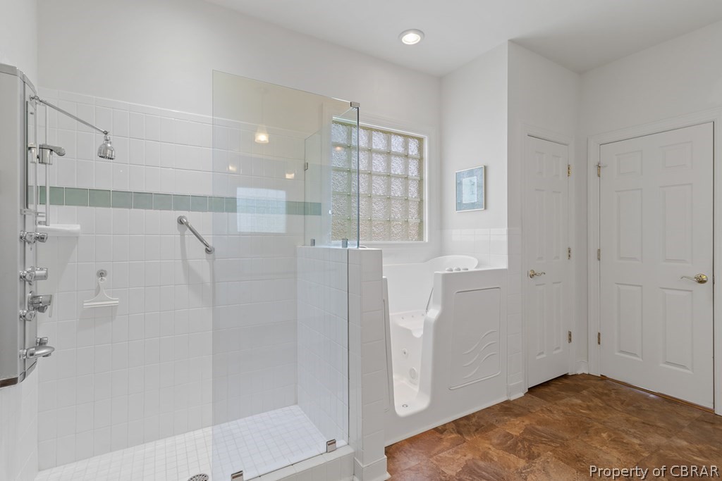 Bathroom with a shower with door and tile floors