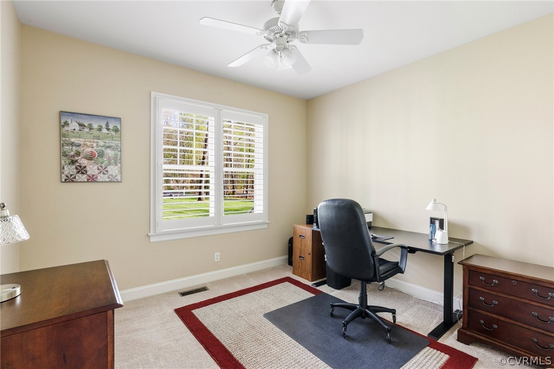 Office area with ceiling fan and light carpet