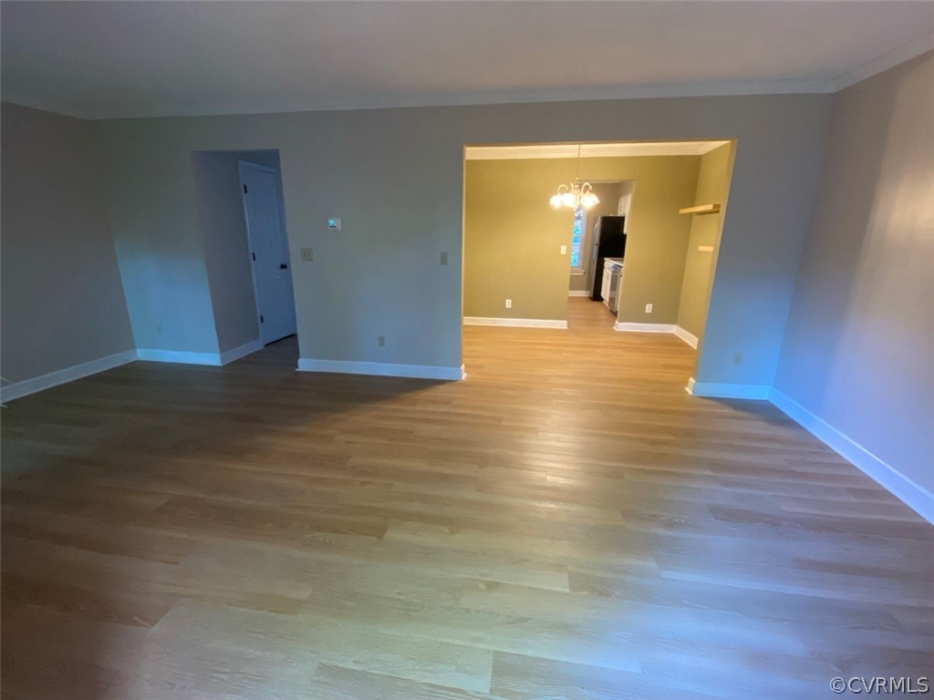 Spare room with a chandelier and hardwood / wood-style flooring