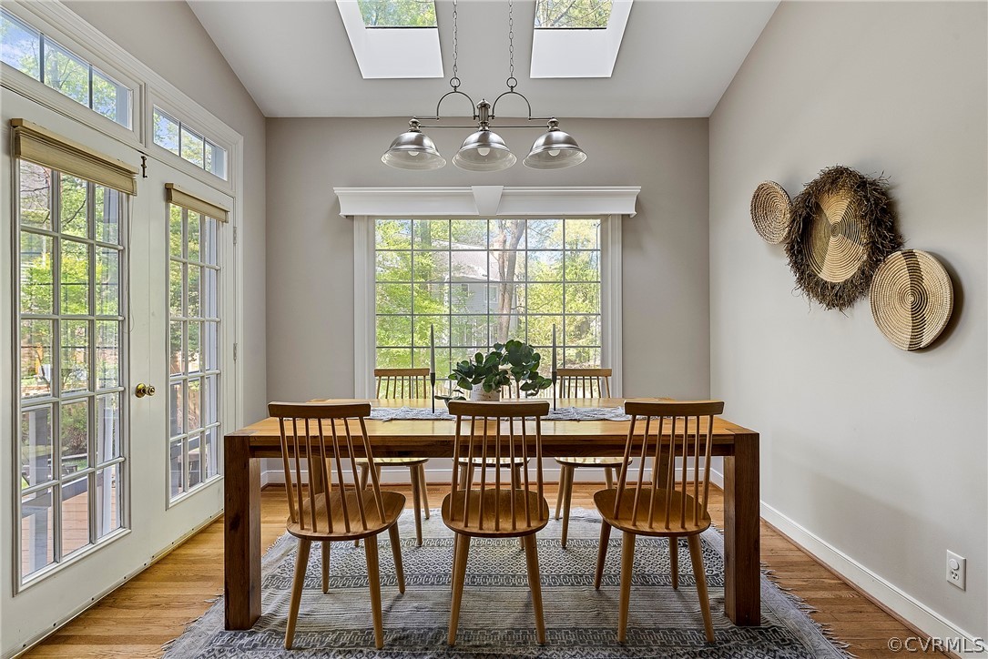 Dining area with vaulted ceiling with skylights