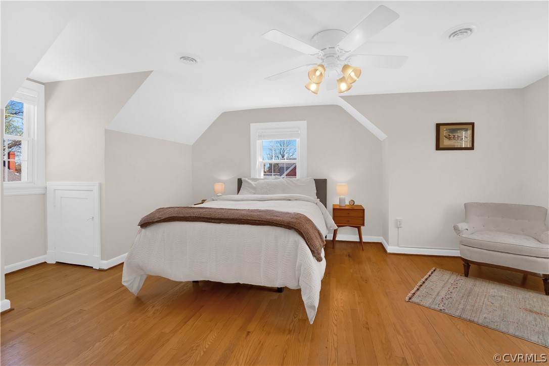 Primary bedroom features fresh paint, hardwood floors, ceiling fan and a sitting area!