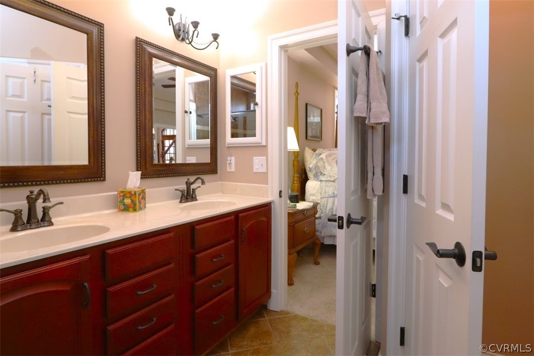 Bathroom featuring large vanity, double sink, and tile flooring