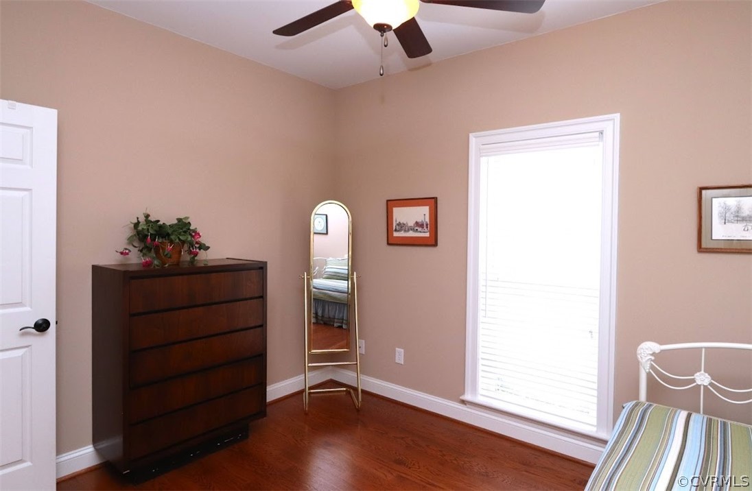 Front bedroom with ceiling fan and wood flooring