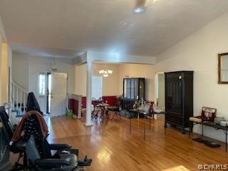 Workout area with a notable chandelier, decorative columns, and hardwood / wood-style flooring