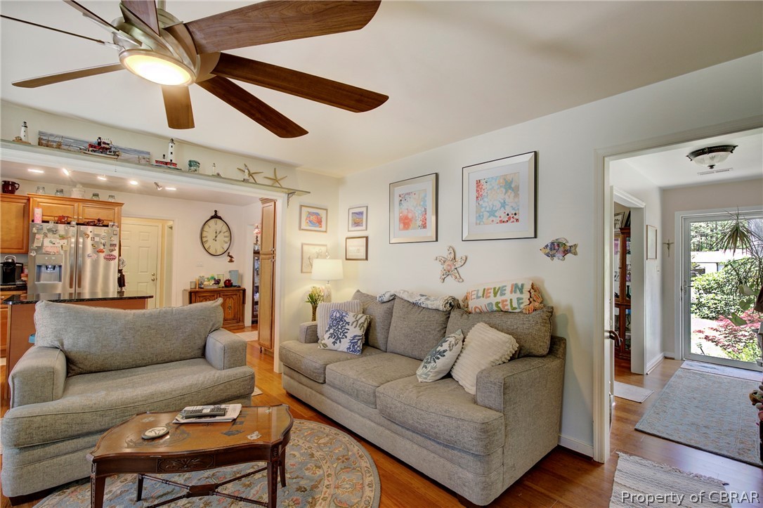 Living room with ceiling fan and hardwood / wood-style floors