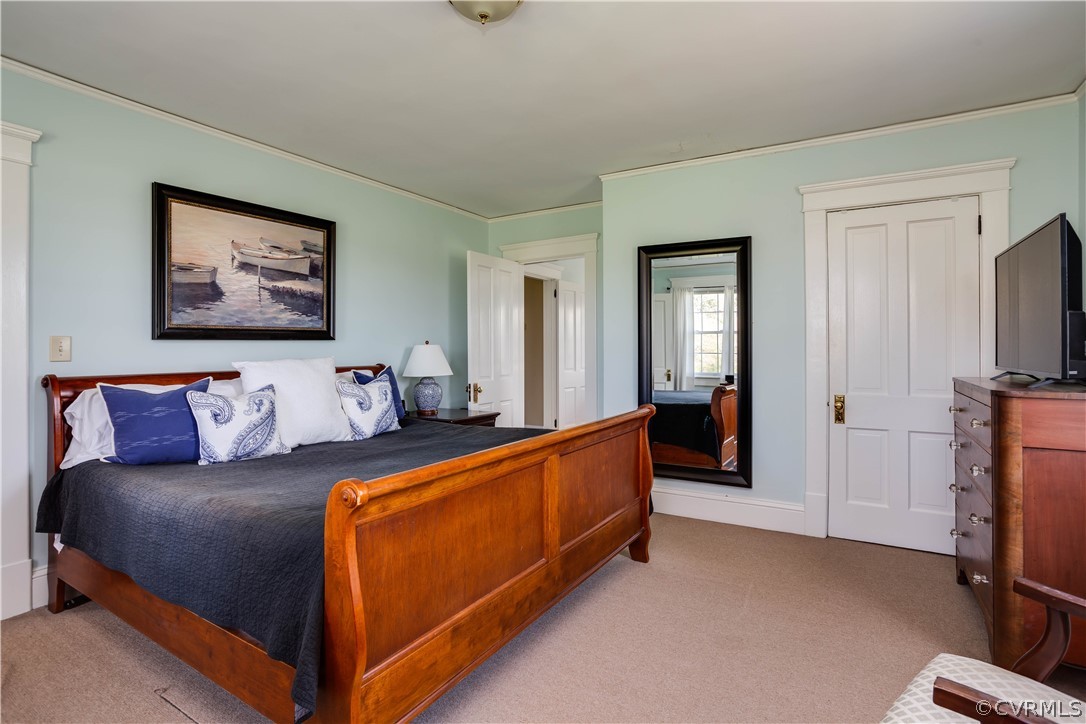 Bedroom featuring light colored carpet and ornamental molding