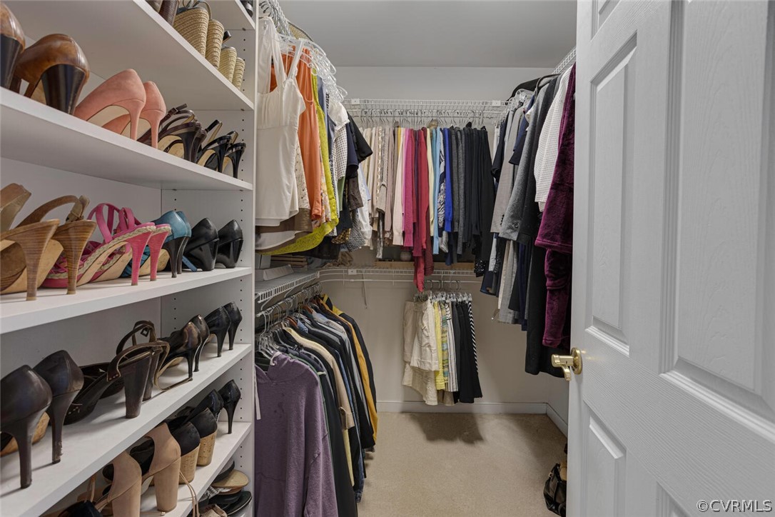Her closet with built-in shelves, carpet.