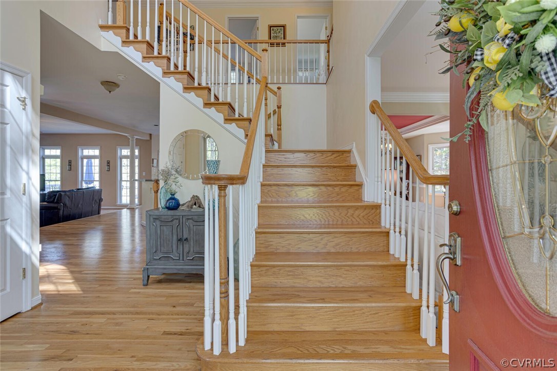 Airy and open 2-story foyer with double staircase, deep crown moldings and newly refinished hardwood floors.