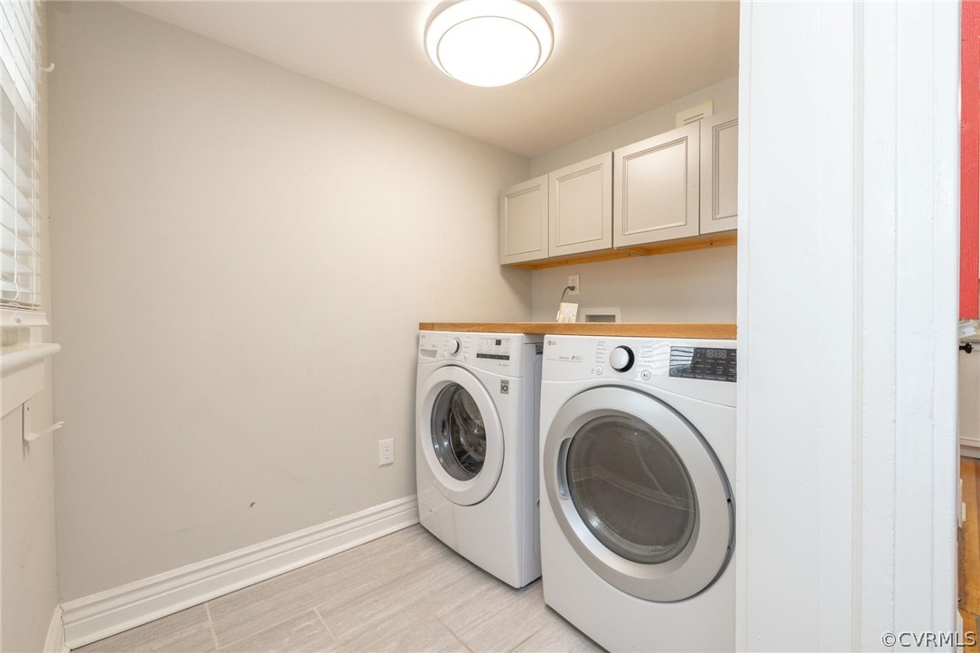 Laundry area with washer hookup, washing machine and clothes dryer, and cabinets