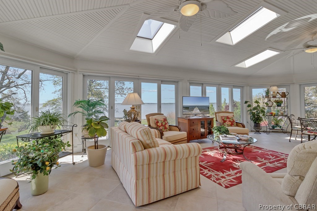 Sunroom featuring a skylight, ceiling fan, and a wealth of natural light