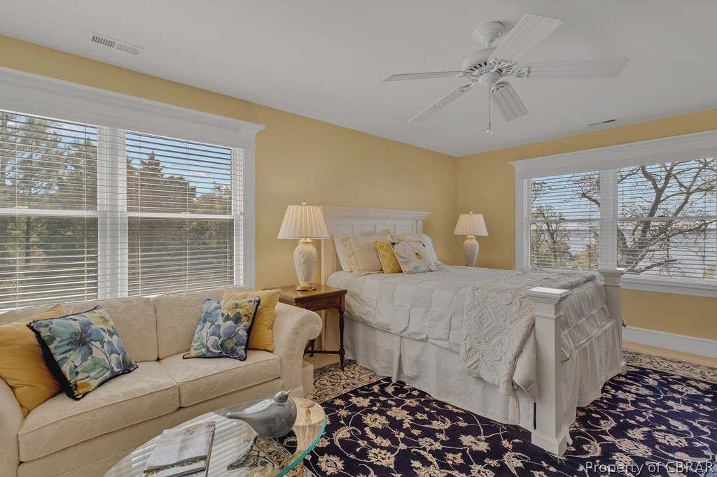 Bedroom featuring carpet, ceiling fan, and multiple windows