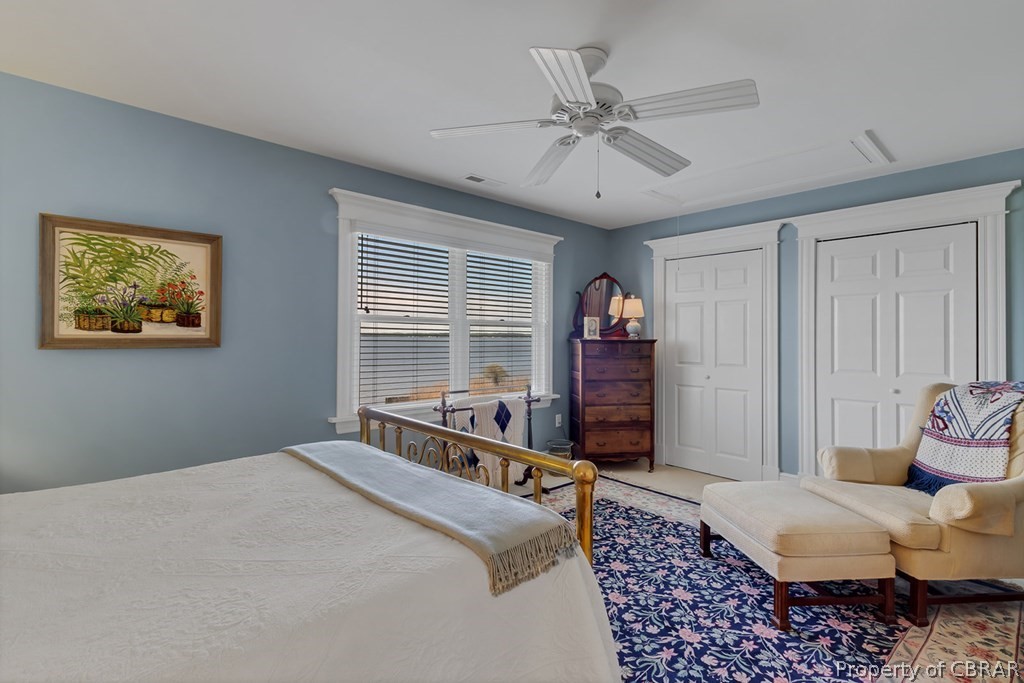 Bedroom with ceiling fan and multiple closets