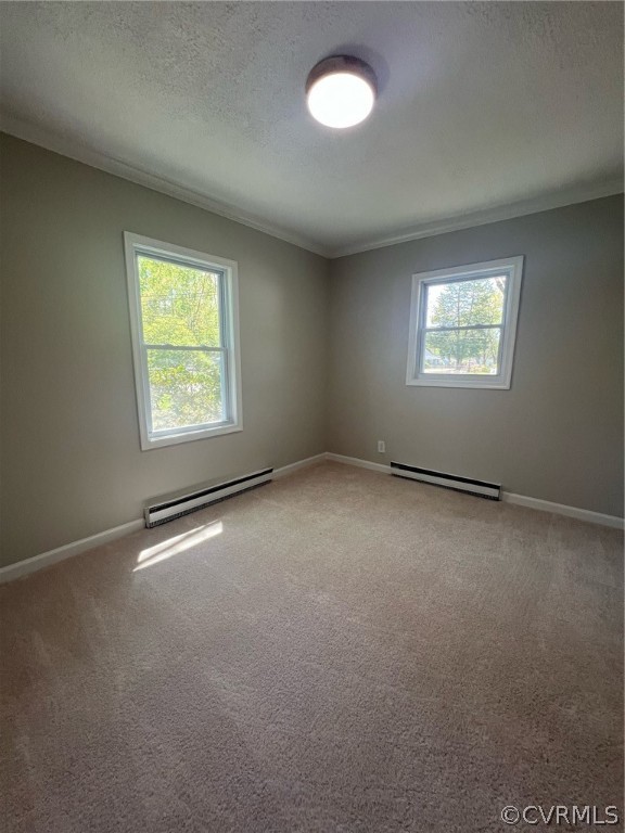Unfurnished room featuring ornamental molding, carpet, and a baseboard heating unit