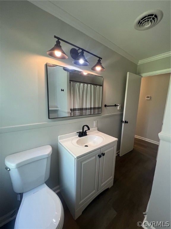 Bathroom with ornamental molding, hardwood / wood-style floors, oversized vanity, and toilet