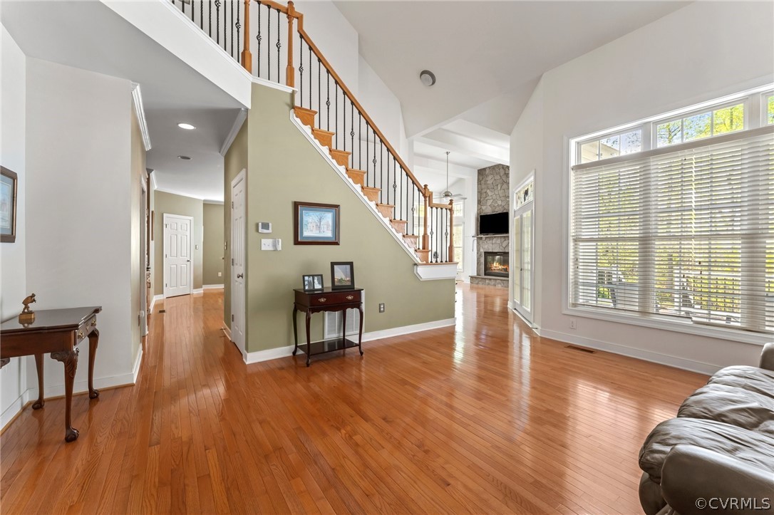 Foyer featuring light hardwood / wood-style flooring, a wealth of natural light, a fireplace, and a high ceiling