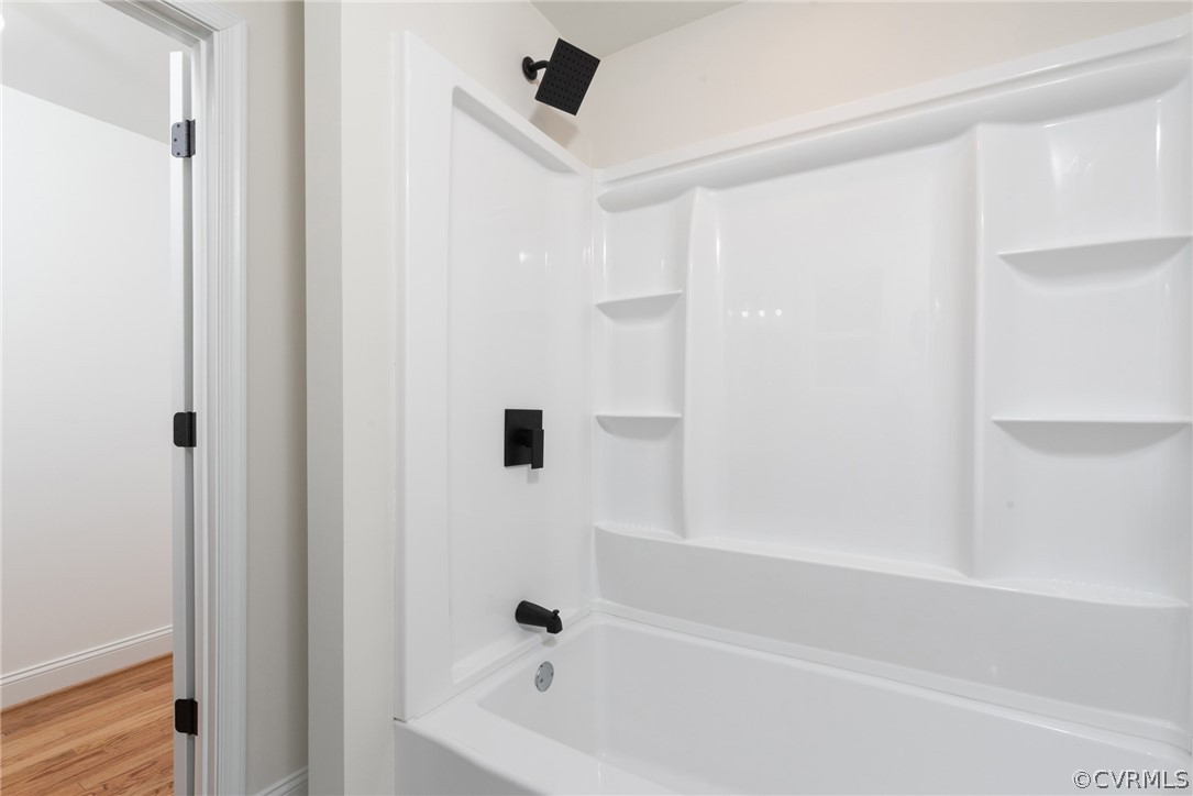 Bathroom featuring wood-type flooring and bathtub / shower combination