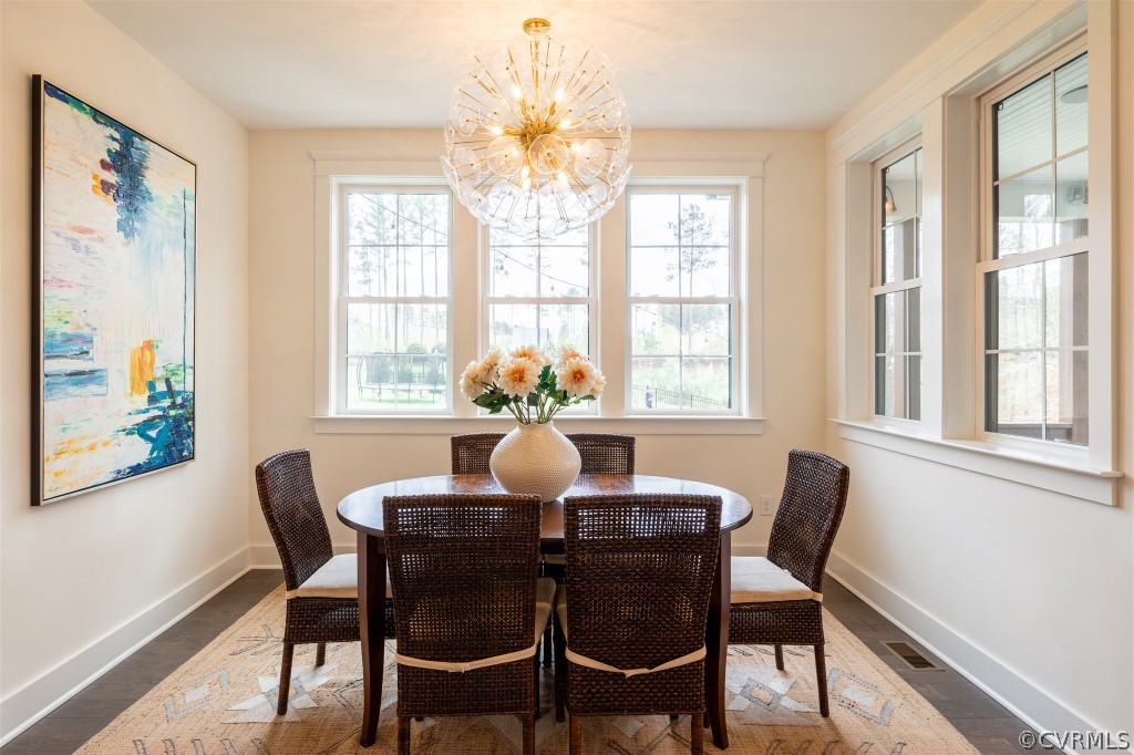 Dining space featuring a wealth of natural light, a chandelier, and dark hardwood / wood-style floors
