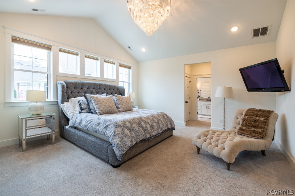 Bedroom featuring a chandelier, ensuite bath, light carpet, and vaulted ceiling