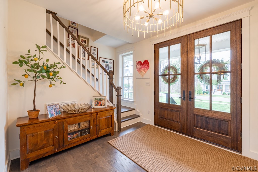 Entryway with french doors, an inviting chandelier, dark hardwood / wood-style flooring, and a wealth of natural light